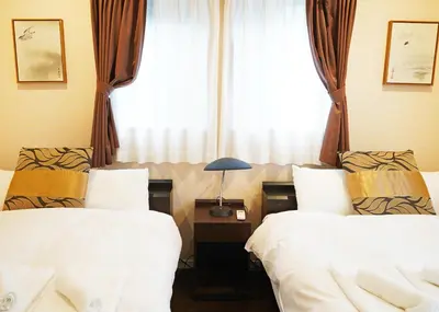 two beds in a hotel room with a window at \u6d45\u8349\u30b6 \u30a2\u30d1\u30fc\u30c8\u30e1\u30f3\u30c8 Asakusa The Apartment in Tokyo
