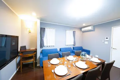a dining room with a table and blue chairs at \u6d45\u8349\u30b6 \u30a2\u30d1\u30fc\u30c8\u30e1\u30f3\u30c8 Asakusa The Apartment in Tokyo