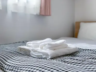 a pile of towels sitting on top of a bed at japan house edogawabashi in Tokyo