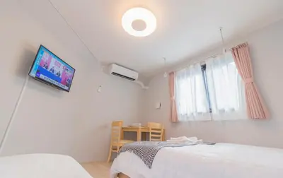 a room with two beds and a tv on the wall at japan house edogawabashi in Tokyo
