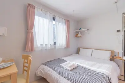 a bedroom with a bed and a desk and a window at japan house edogawabashi in Tokyo