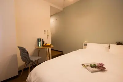 a bedroom with a white bed with a tray of flowers on it at nestay apartment tokyo ikebukuro in Tokyo