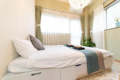 a bedroom with a large bed with a window at nestay apartment tokyo ikebukuro in Tokyo
