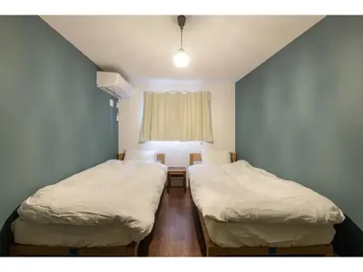 two twin beds in a room with a window at rakuna Inn Dou-sasazuka - Vacation STAY 47231v in Tokyo