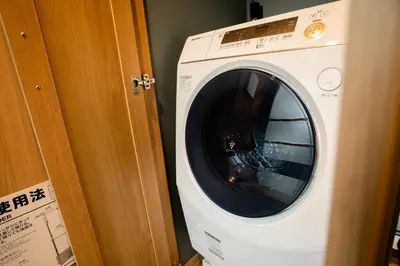 a white washing machine sitting next to a door at THE BONDS HOTEL TOKYO - Vacation STAY 48446v in Tokyo