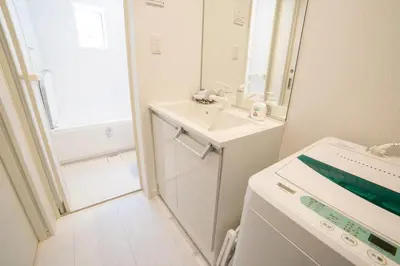 a white bathroom with a sink and a mirror at Skytree view Oshiage in Tokyo