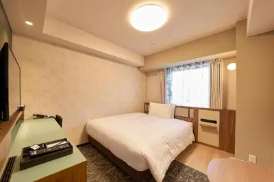 a bedroom with a bed and a desk and a television at Keisei Richmond Hotel Tokyo Kinshicho in Tokyo