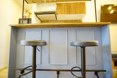a kitchen with two bar stools in front of a counter at \u8cb8\u5207\u4e00\u8ed2\u5bb6 \u6771\u4eac\u30f4\u30a3\u30e9 \u30ea\u30d0\u30fc\u30b5\u30a4\u30c9\u5e73\u4e95 in Tokyo