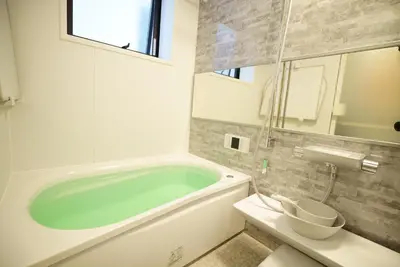 a bathroom with a bath tub and a toilet at \u8cb8\u5207\u4e00\u8ed2\u5bb6 \u6771\u4eac\u30f4\u30a3\u30e9 \u30ea\u30d0\u30fc\u30b5\u30a4\u30c9\u5e73\u4e95 in Tokyo