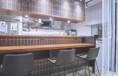 a kitchen with a bar with four chairs in it at Asakusa Kaede \u6d45\u8349\u6953 in Tokyo