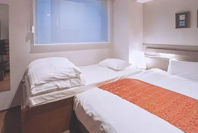 a bedroom with two beds and a window at Asakusa Kaede \u6d45\u8349\u6953 in Tokyo