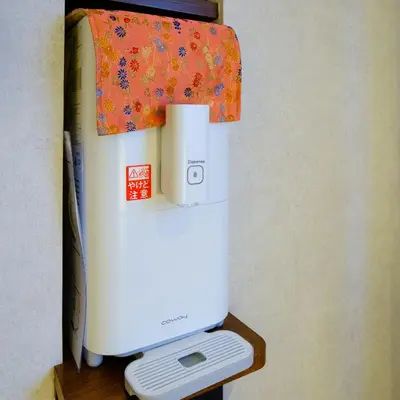 a white refrigerator sitting on a wooden stand next to a wall at Asakusa Kaede \u6d45\u8349\u6953 in Tokyo