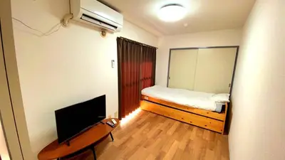 a small bedroom with a bed and a television at Esperanza 303\u53f7\u5ba4 in Tokyo