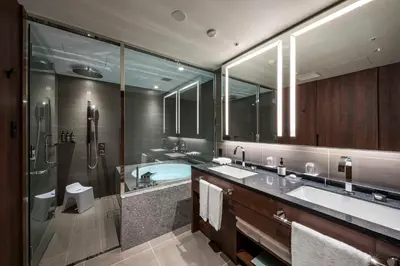 a bathroom with two sinks and a shower and a tub at Hotel GrandBach Tokyo Ginza in Tokyo