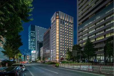 a tall building on a city street at night at Hotel GrandBach Tokyo Ginza in Tokyo