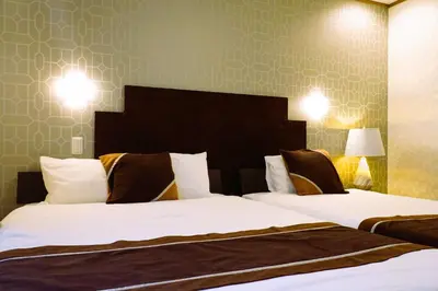 a hotel room with two beds and two lamps at Shinjuku Sakaue House in Tokyo