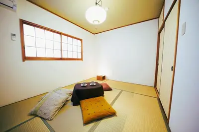 a room with a table and two pillows on the floor at Shinjuku Sakaue House in Tokyo