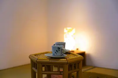 a cup and saucer on a table with a lamp at Shinjuku Sakaue House in Tokyo