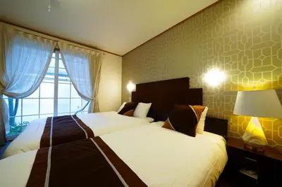 a hotel room with two beds and a window at Shinjuku Sakaue House in Tokyo