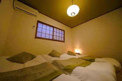 a room with two beds in it with a window at Shinjuku Sakaue House in Tokyo