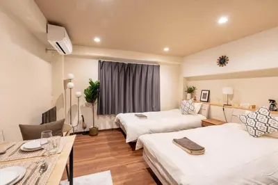 a hotel room with two beds and a table at Ostay Ikebukuro Dairaku Hotel Apartment in Tokyo