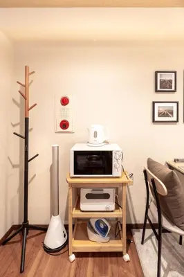 a small table with a microwave on top of it at Ostay Ikebukuro Dairaku Hotel Apartment in Tokyo