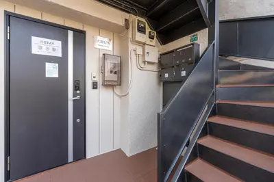 a corridor with a door and stairs in a room at Ostay Ikebukuro Dairaku Hotel Apartment in Tokyo