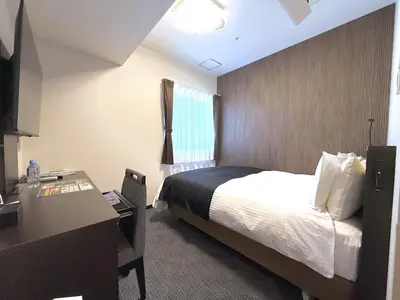 a hotel room with a bed and a desk at APA Hotel Keikyu Kamata Ekimae Nishi in Tokyo