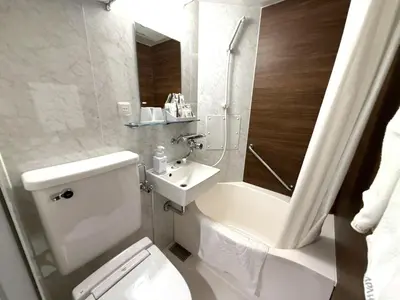 a white bathroom with a toilet and a sink at APA Hotel Keikyu Kamata Ekimae Nishi in Tokyo