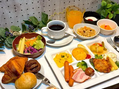 a table with plates of food and a cup of coffee at APA Hotel Keikyu Kamata Ekimae Nishi in Tokyo