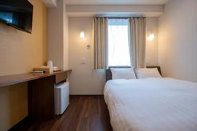 a hotel room with a bed and a window at ELE Hotel \u6771\u4e0a\u91ce in Tokyo
