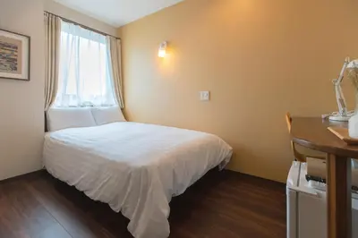 a small room with a bed and a window at ELE Hotel \u6771\u4e0a\u91ce in Tokyo