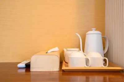 a table with a tea pot and cups and a coffee maker at ELE Hotel \u6771\u4e0a\u91ce in Tokyo