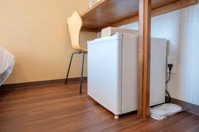 a white refrigerator in a room with a lamp at ELE Hotel \u6771\u4e0a\u91ce in Tokyo