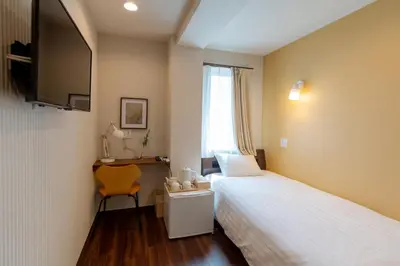 a hotel room with a bed and a desk and a television at ELE Hotel \u6771\u4e0a\u91ce in Tokyo