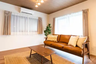 a living room with a brown leather couch and a table at GIVE Shibuya Honmachi in Tokyo