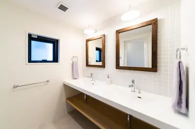 a bathroom with two sinks and two mirrors at GIVE Shibuya Honmachi in Tokyo