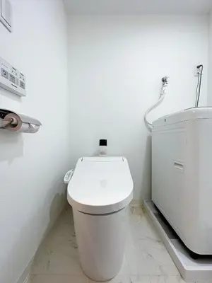 a white bathroom with a toilet and a sink at nestay inn tokyo ryogoku in Tokyo