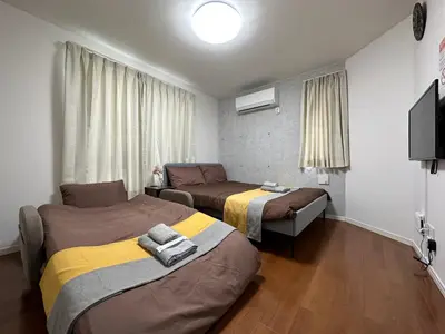 a hotel room with two beds and a television at nestay inn tokyo ryogoku in Tokyo