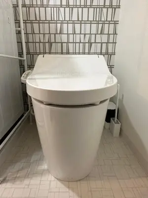 a white toilet in a bathroom with a tiled wall at nestay inn tokyo ryogoku in Tokyo