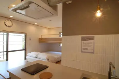 a room with a bed and a clock on the wall at Hotel Futaba Heights -\u30d5\u30bf\u30d0\u30cf\u30a4\u30c4- in Tokyo
