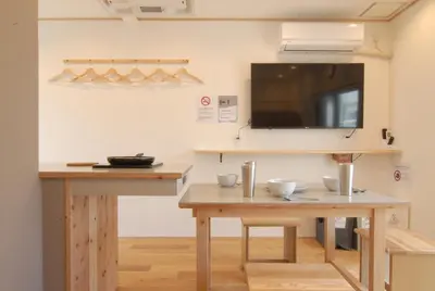 a room with two tables and a flat screen tv at Hotel Futaba Heights -\u30d5\u30bf\u30d0\u30cf\u30a4\u30c4- in Tokyo