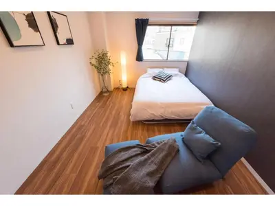a bedroom with a bed and a couch and a window at Tora Hotel Skytree - Vacation STAY 51803v in Tokyo