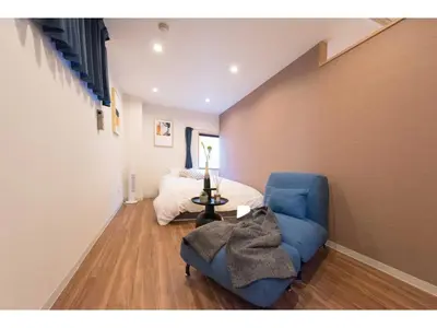 a living room with a blue couch and a bed at Tora Hotel Skytree - Vacation STAY 51801v in Tokyo