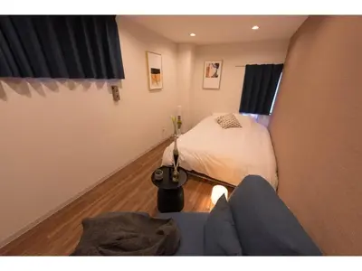 a room with a bed and a person sitting on a couch at Tora Hotel Skytree - Vacation STAY 51801v in Tokyo