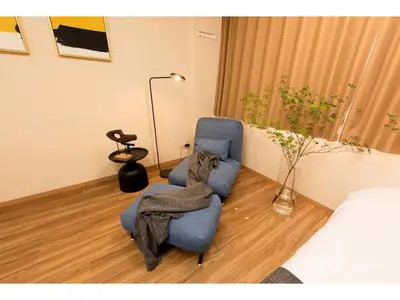 a bedroom with a bed and a blue chair and a blanket at Tora Hotel Rikugien - Vacation STAY 52738v in Tokyo