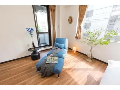 a living room with a blue chair and a table at Tora Hotel Rikugien - Vacation STAY 52738v in Tokyo