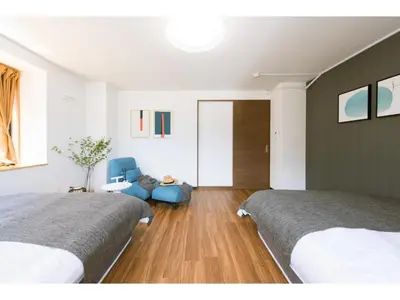 a bedroom with two beds and a blue chair at Tora Hotel Rikugien - Vacation STAY 52741v in Tokyo