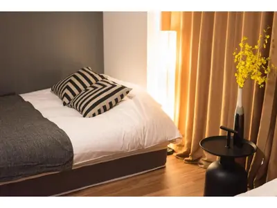 a bedroom with a bed and a table and a window at Tora Hotel Rikugien - Vacation STAY 52741v in Tokyo