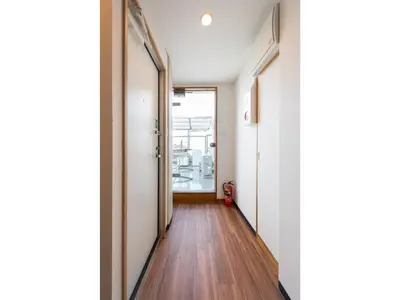 a hallway with white walls and wooden floors and a door at Tora Hotel Rikugien - Vacation STAY 52744v in Tokyo